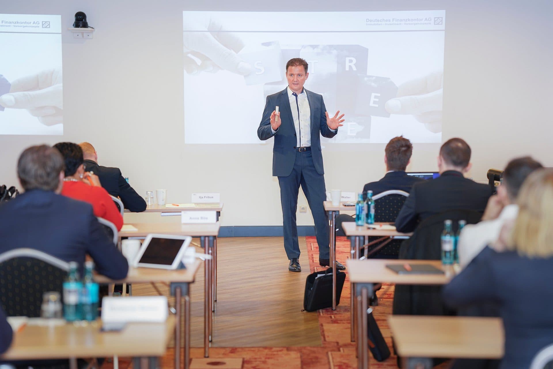 Referent hält vor Publikum einen Vortrag in einem Seminarraum der DFK Group.