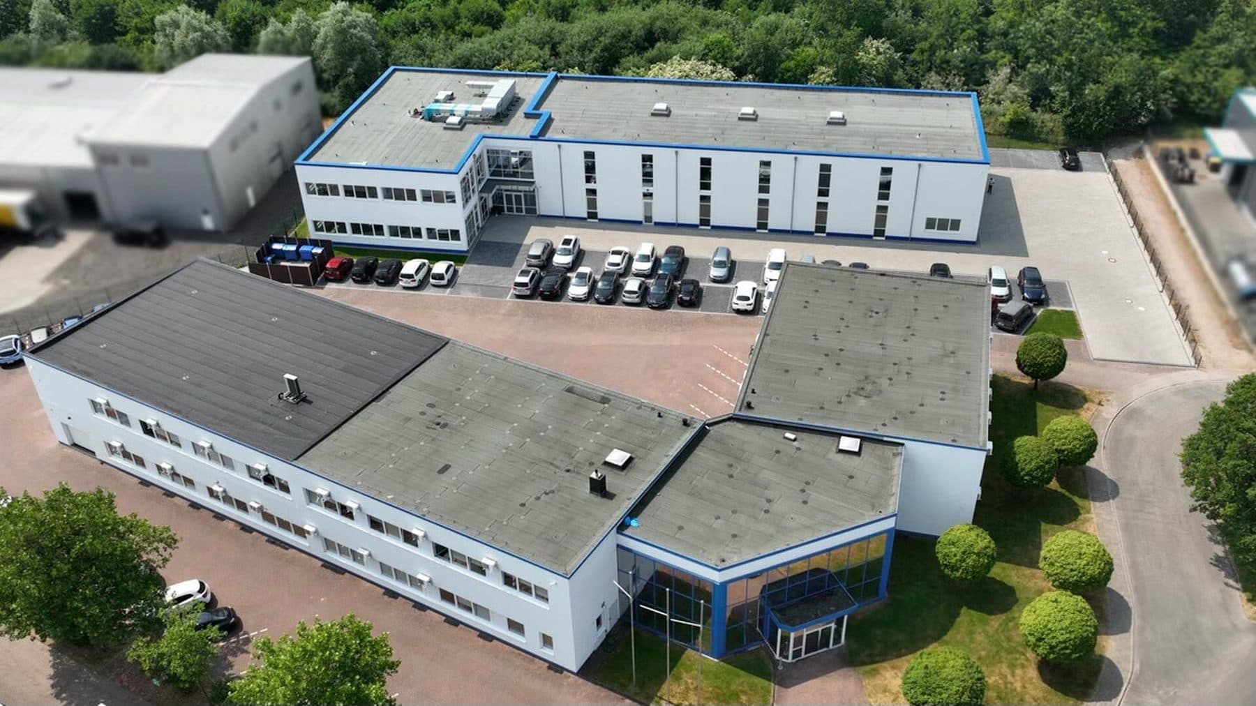 Luftbild der DFK Zentrale in Kaltenkirchen mit Parkplätzen vor dem Gebäude.